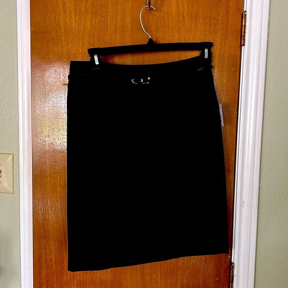 Black lined skit with slim belt. Never worn new with tags. Kick pleat in back